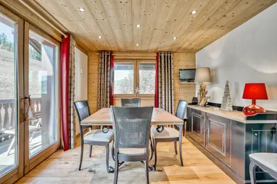 a dining room with a table and chairs at Marmots in Megève