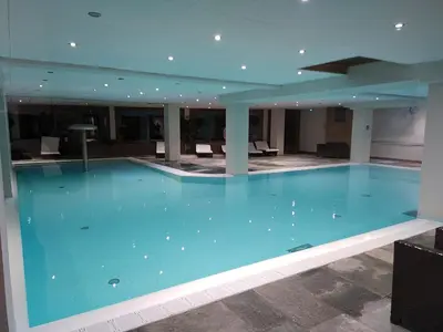 a large blue swimming pool in a building at Duplex résidence spa Mont-Blanc in Vallorcine