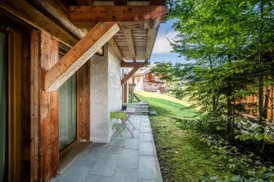 a porch of a house with a table and chairs at Chalet Purdey Combloux - BY EMERALD STAY in Combloux