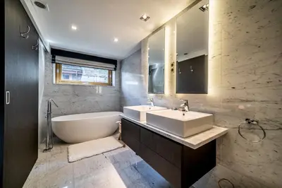 a bathroom with a tub and a sink and a bath tub at Chalet Purdey Combloux - BY EMERALD STAY in Combloux
