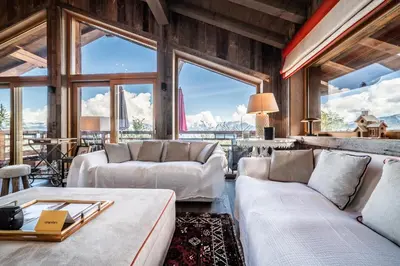 a living room with white couches and large windows at Chalet Purdey Combloux - BY EMERALD STAY in Combloux