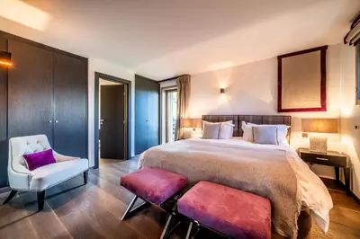 a bedroom with a large bed and two chairs at Chalet Purdey Combloux - BY EMERALD STAY in Combloux