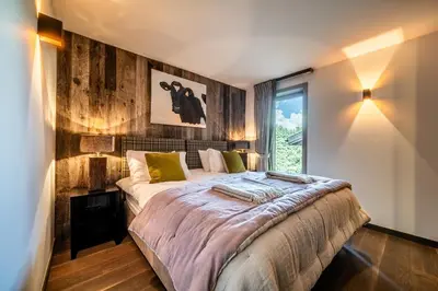 a bedroom with a bed and a large window at Chalet Purdey Combloux - BY EMERALD STAY in Combloux