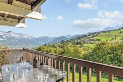 a table on a balcony with a view of mountains at Appartement Chablis - Welkeys in Combloux