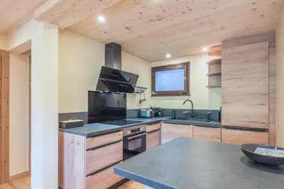 a kitchen with wooden cabinets and a counter top at Appartement Chablis - Welkeys in Combloux