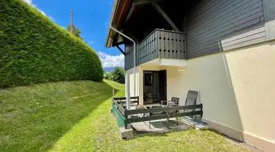 a house with a porch with two chairs on it at Studio rénové avec terrasse Sud idéalement situé in Combloux