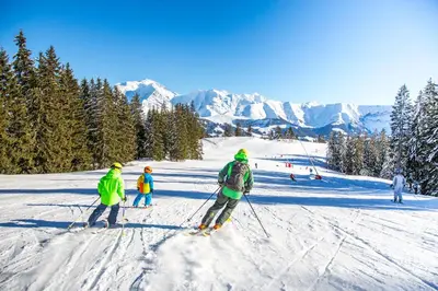 a group of people skiing down a snow covered slope at Studio rénové avec terrasse Sud idéalement situé in Combloux