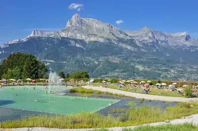 a group of people swimming in a pool with a mountain at Studio rénové avec terrasse Sud idéalement situé in Combloux