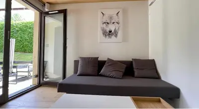 a couch in a living room with a picture of a wolf at Studio rénové avec terrasse Sud idéalement situé in Combloux