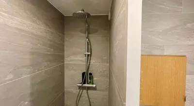 a shower with a shower head in a bathroom at Studio rénové avec terrasse Sud idéalement situé in Combloux