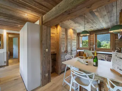 a kitchen and dining room with wooden walls and a white refrigerator at Appartement rénové à 150m des remontées, terrasse et parking couvert - FR-1-569-126 in Megève
