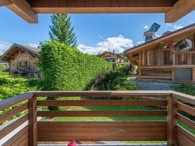 a wooden fence in front of a house at Appartement rénové à 150m des remontées, terrasse et parking couvert - FR-1-569-126 in Megève