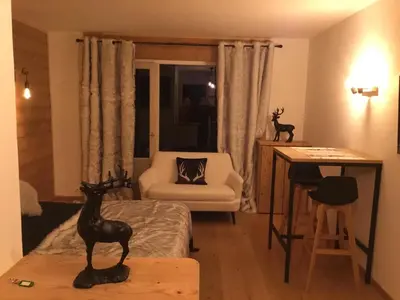 a bedroom with a bed and a desk with a chair at Studio du cerf in Megève