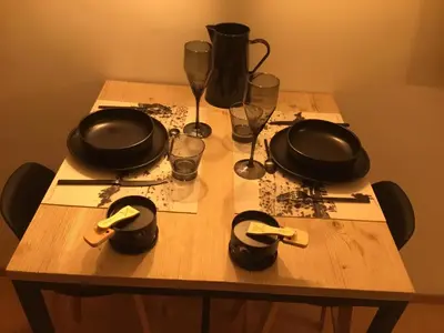 a wooden table with glasses and pans on it at Studio du cerf in Megève