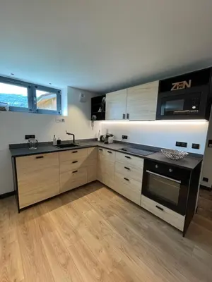 a kitchen with wooden cabinets and a stove top oven at Appartement - La Meute in Magland
