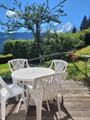 a white table and chairs on a wooden deck at Bethel-Mont-Blanc in Saint-Gervais-les-Bains