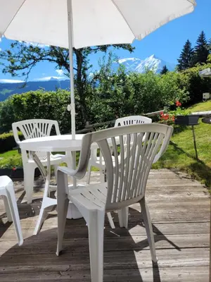 a white table and chairs with an umbrella at Bethel-Mont-Blanc in Saint-Gervais-les-Bains
