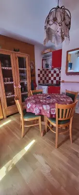 a dining room with a table and chairs and a kitchen at Appartement montagnard avec vue sur le Mont-Blanc in Saint-Gervais-les-Bains