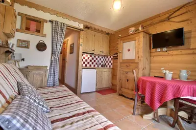 a living room with a table and a kitchen at Studio coin nuit style chalet in Saint-Gervais-les-Bains