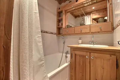 a bathroom with a tub and a sink and a shower at Studio coin nuit style chalet in Saint-Gervais-les-Bains