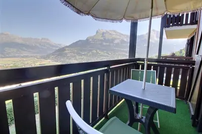 a table and chairs on a balcony with a view at Studio coin nuit style chalet in Saint-Gervais-les-Bains