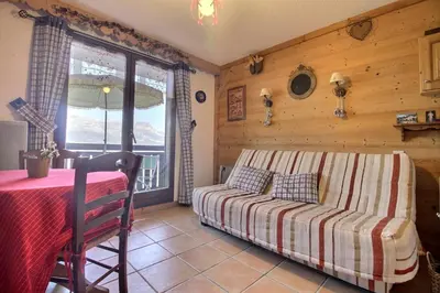 a bedroom with a bed and a table and a window at Studio coin nuit style chalet in Saint-Gervais-les-Bains