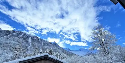 a snow covered roof of a house with a mountain at White Pearl Vue Mont Blanc in Chamonix-Mont-Blanc