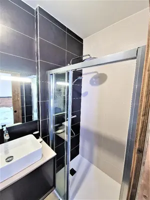a bathroom with a glass shower and a sink at White Pearl Vue Mont Blanc in Chamonix-Mont-Blanc