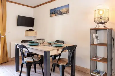 a dining room with a table and chairs at Sapins 11 - Appartement familial - Pied des pistes - Vue sur les montagnes in Les Houches