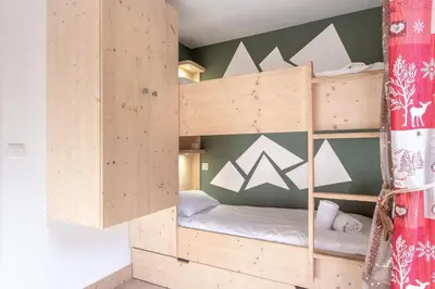 a wooden bunk bed in a room at Sapins 11 - Appartement familial - Pied des pistes - Vue sur les montagnes in Les Houches