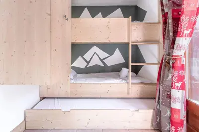 a wooden bunk bed in a room at Sapins 11 - Appartement familial - Pied des pistes - Vue sur les montagnes in Les Houches