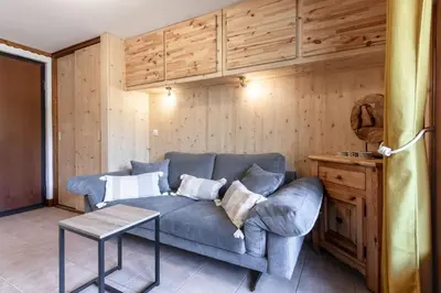 a living room with a blue couch and a table at Sapins 11 - Appartement familial - Pied des pistes - Vue sur les montagnes in Les Houches