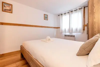 a bedroom with a white bed and a window at Chalet Eveland - Proche du centre-ville - Calme in Les Houches