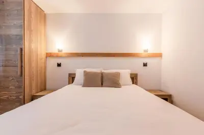 a bedroom with a large white bed with two pillows at Chalet Eveland - Proche du centre-ville - Calme in Les Houches