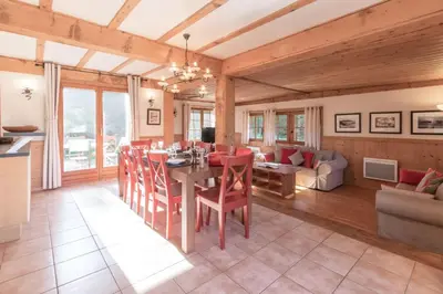 a dining room and living room with a table and chairs at Chalet Eveland - Proche du centre-ville - Calme in Les Houches
