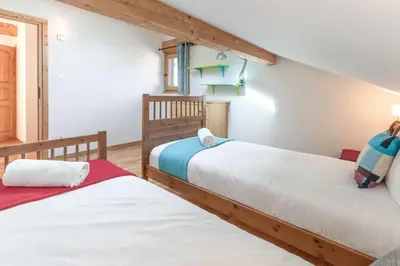 two twin beds in a room with white walls at Chalet Eveland - Proche du centre-ville - Calme in Les Houches