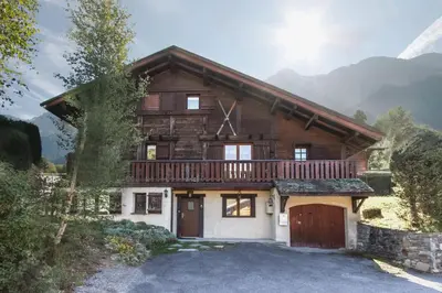 a log house with a balcony and a garage at Chalet Eveland - Proche du centre-ville - Calme in Les Houches