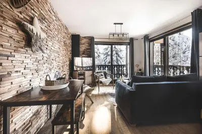 a living room with a couch and a brick wall at Appartement Uccelli - Cocoon just a stone's throw from the centre of Megève in Megève