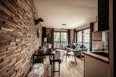 a kitchen and living room with a brick wall at Appartement Uccelli - Cocoon just a stone's throw from the centre of Megève in Megève