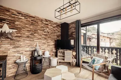 a living room with a brick wall at Appartement Uccelli - Cocoon just a stone's throw from the centre of Megève in Megève