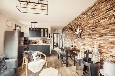 a kitchen and living room with a brick wall at Appartement Uccelli - Cocoon just a stone's throw from the centre of Megève in Megève