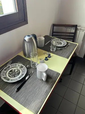 a table with plates and utensils on it at Appartement 109 in Sallanches