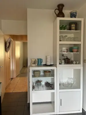 a white cabinet filled with dishes and bowls at Appartement 109 in Sallanches