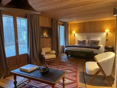 a hotel room with a bed and a table and chairs at RED LODGE in Megève