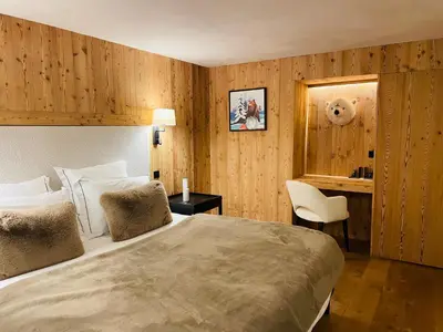 a bedroom with a bed and a desk and a chair at RED LODGE in Megève