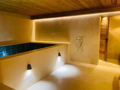 a bathroom with a shower with lights on the wall at RED LODGE in Megève