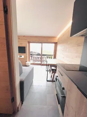 a kitchen and living room with a couch and a table at Appartement 4 personnes pistes in Combloux