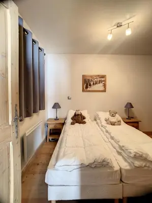 a bedroom with two teddy bears sitting on a bed at rous 03 in Les Carroz d'Araches