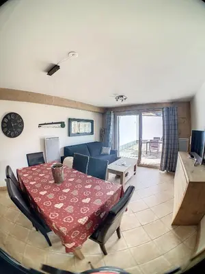 a living room with a table and a blue couch at rous 03 in Les Carroz d'Araches