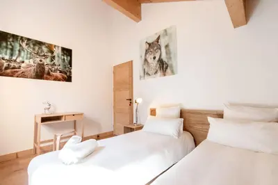 two beds in a room with white walls at Terra Losa 2 - Quiet and modern apartment - City center in Les Houches
